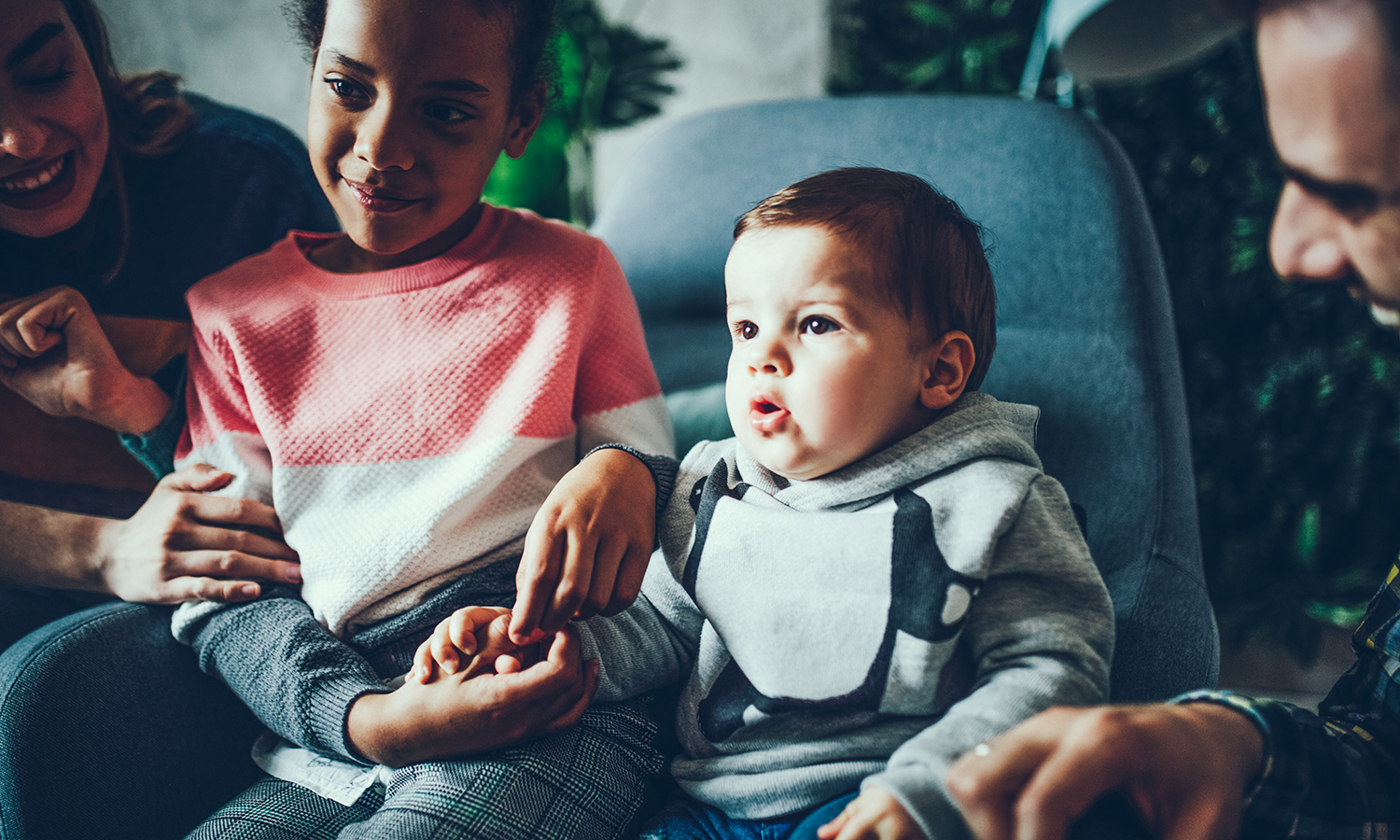 Foster parents watching TV with their children