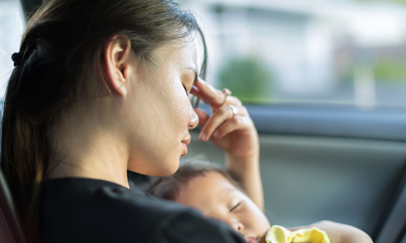 An exhausted mum trying to take a nap with her baby