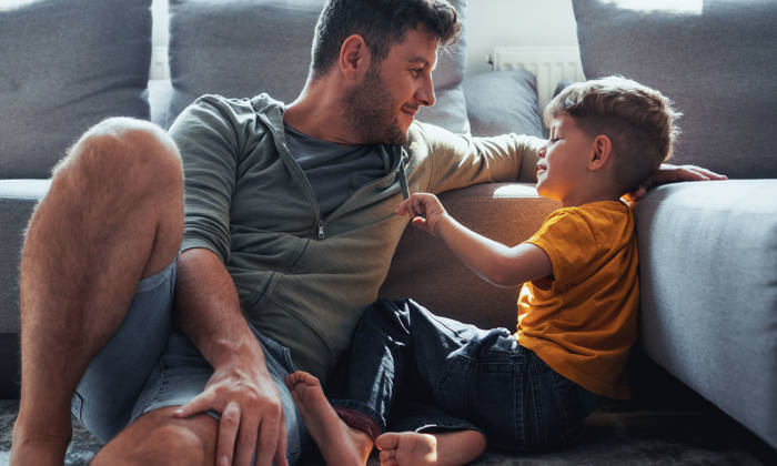 Father and son are spending time in the living room