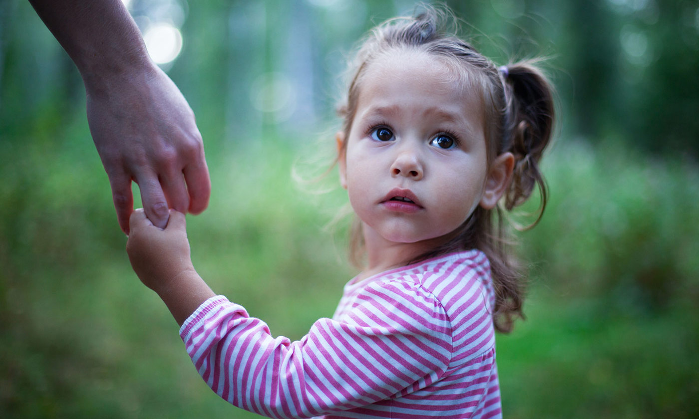 Little girl holding mother's hand