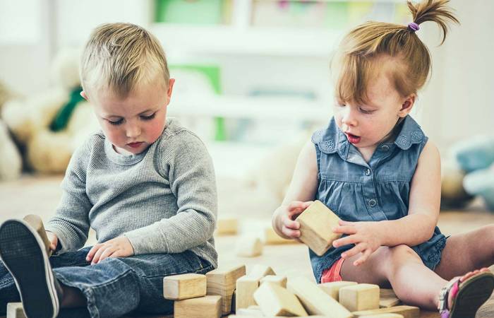 Boy and girl sharing blocks
