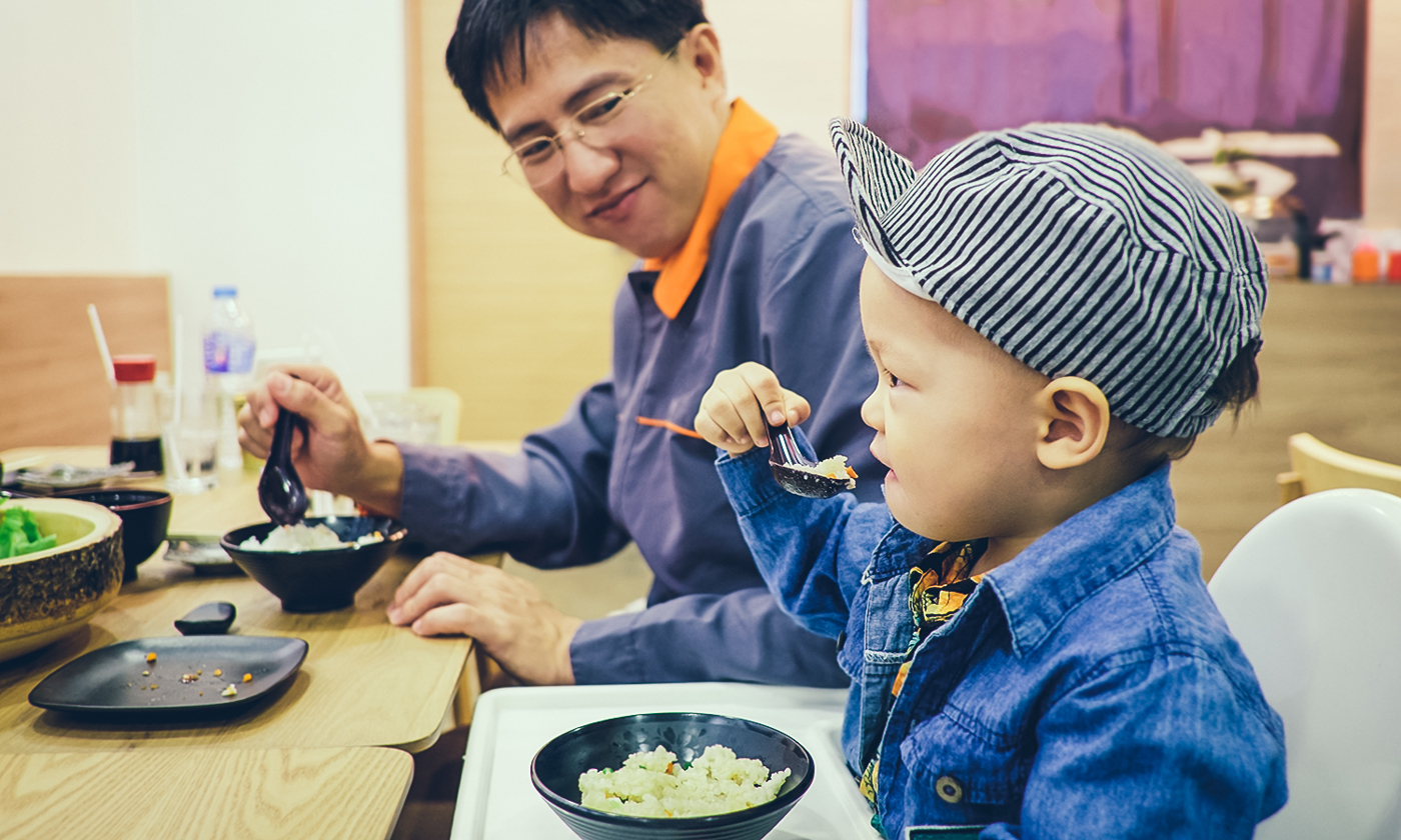 Toddler eating food with fork and spoon