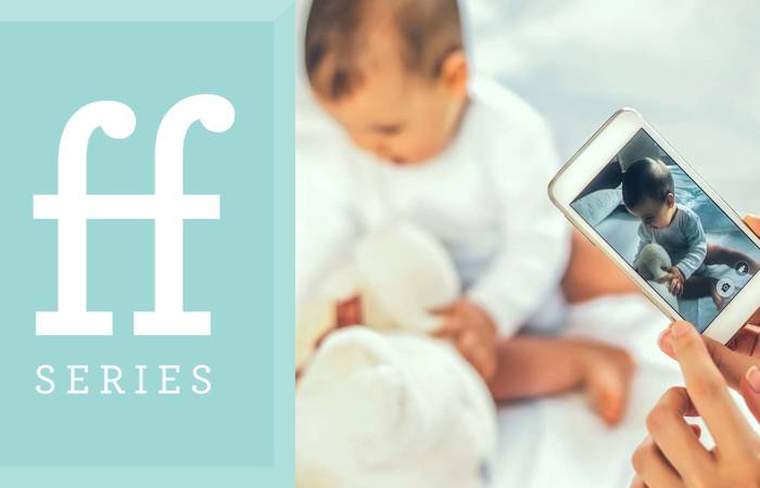 Mother taking photograph of infant