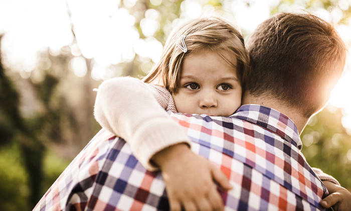 Young girl being consoled by her father