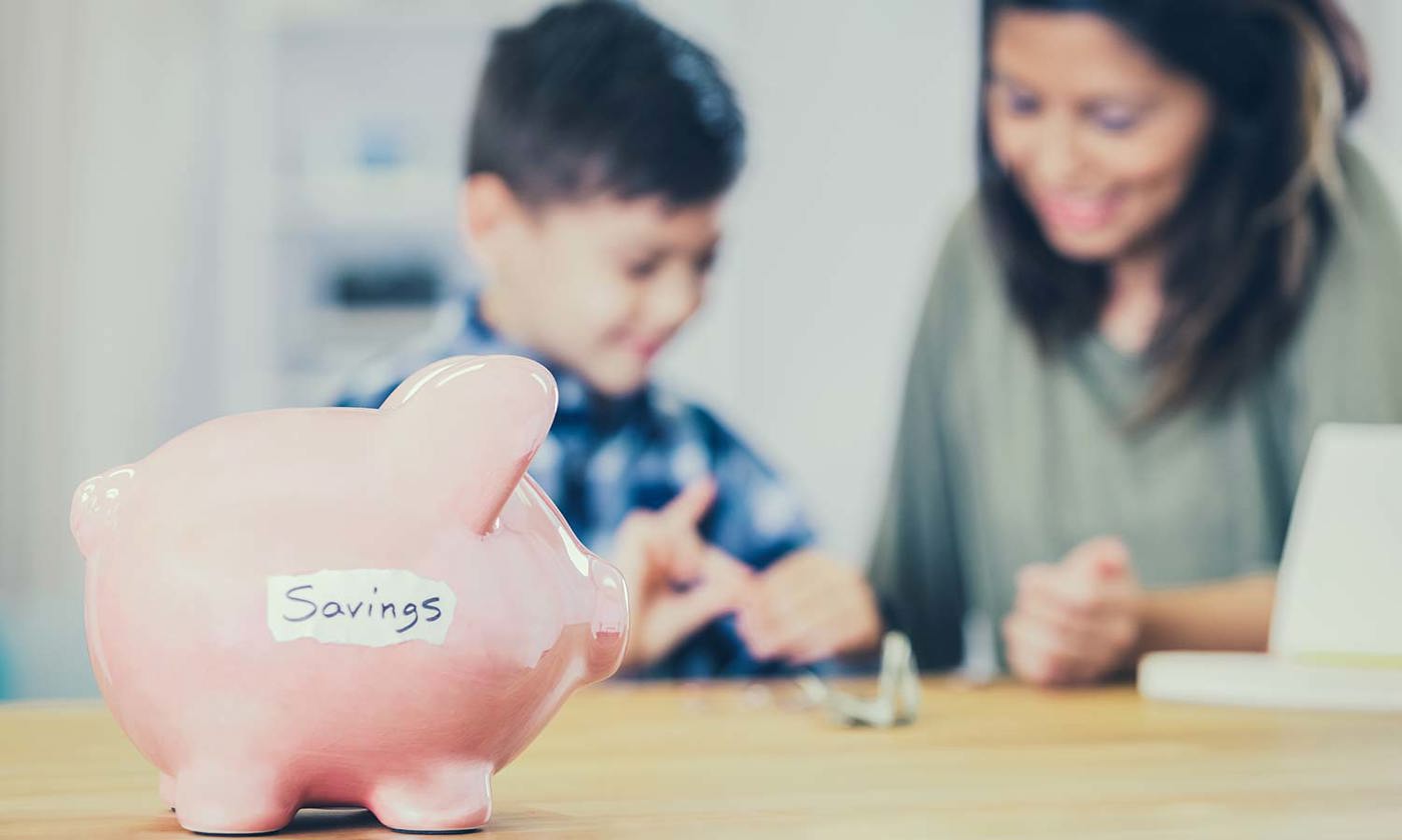 mother and son counting change from piggy bank