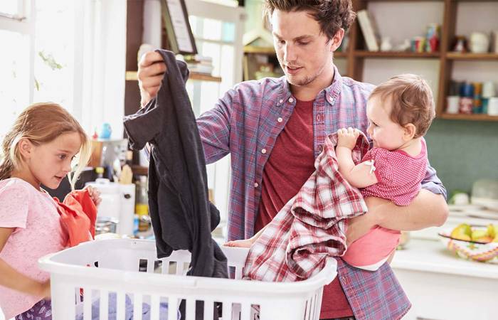 father and child sorting laundry at home