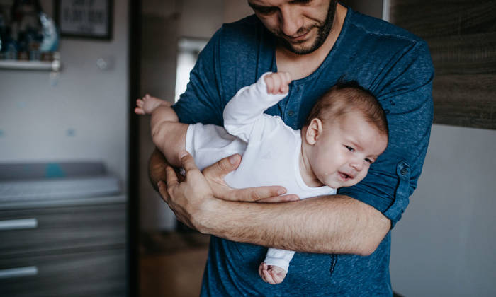 Dad holding crying colic baby
