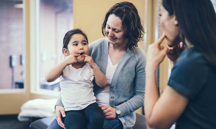 Speech therapist works with kindergarten aged girl