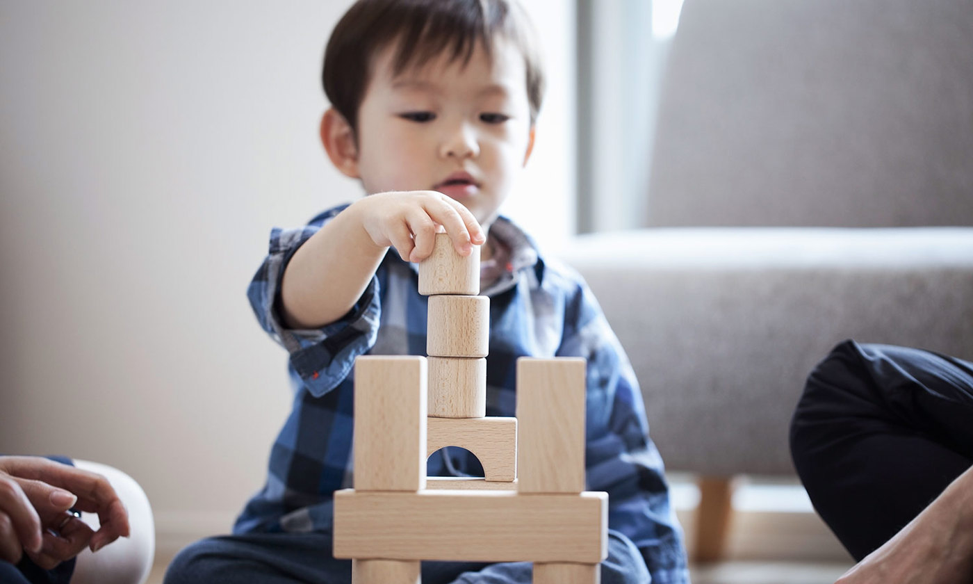 Boy playing with blocks sitting on floor