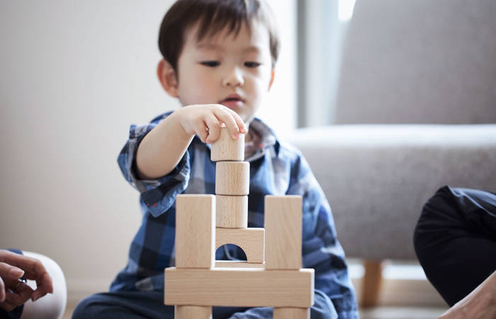 Boy playing with blocks sitting on floor