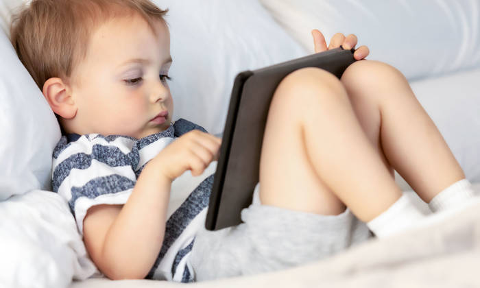 Toddler looking at his electronic tablet