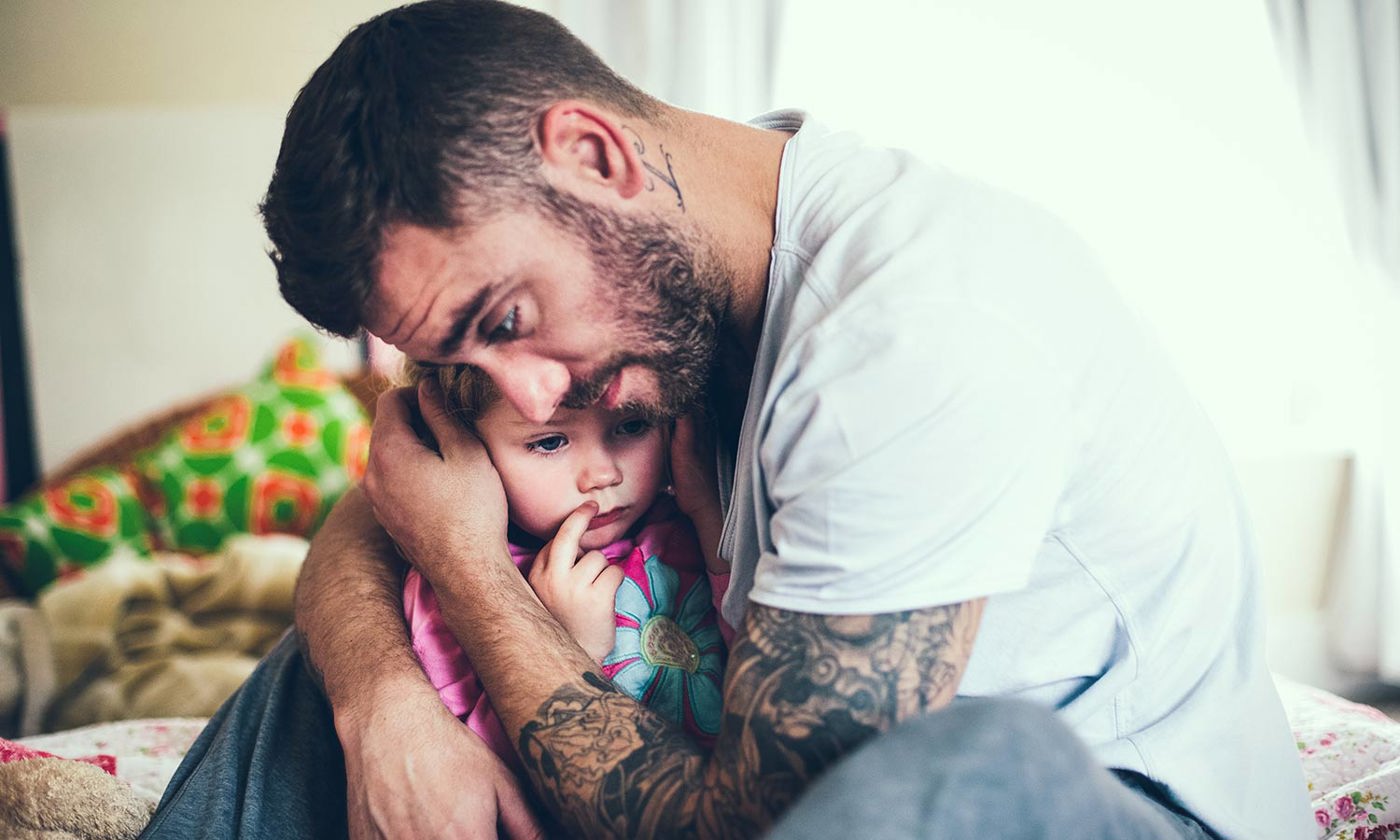 Protective father hugs child