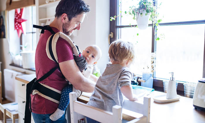 Father and two toddlers washing up the dishes