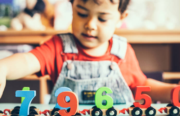 Little boy playing with a mathematics wooden toy