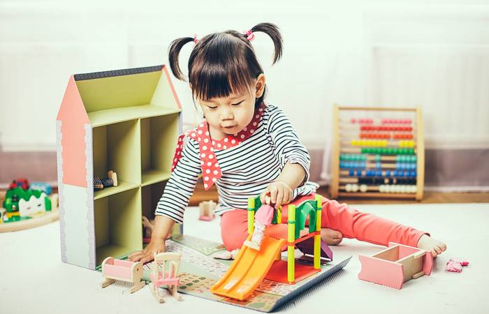 Baby girl playing doll house