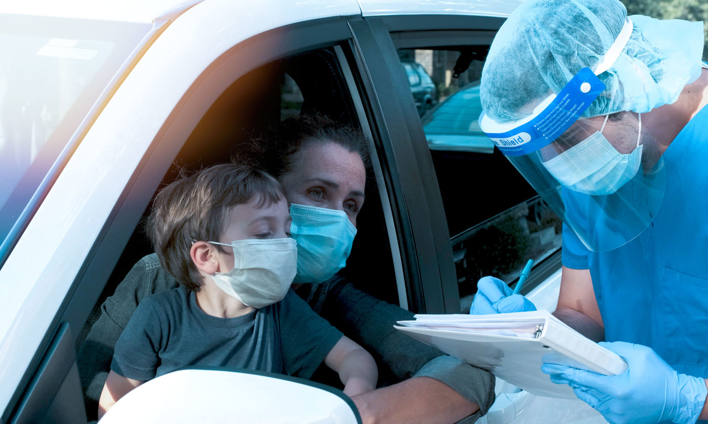 Healthcare worker performing a Covid-19 test to a woman and her son