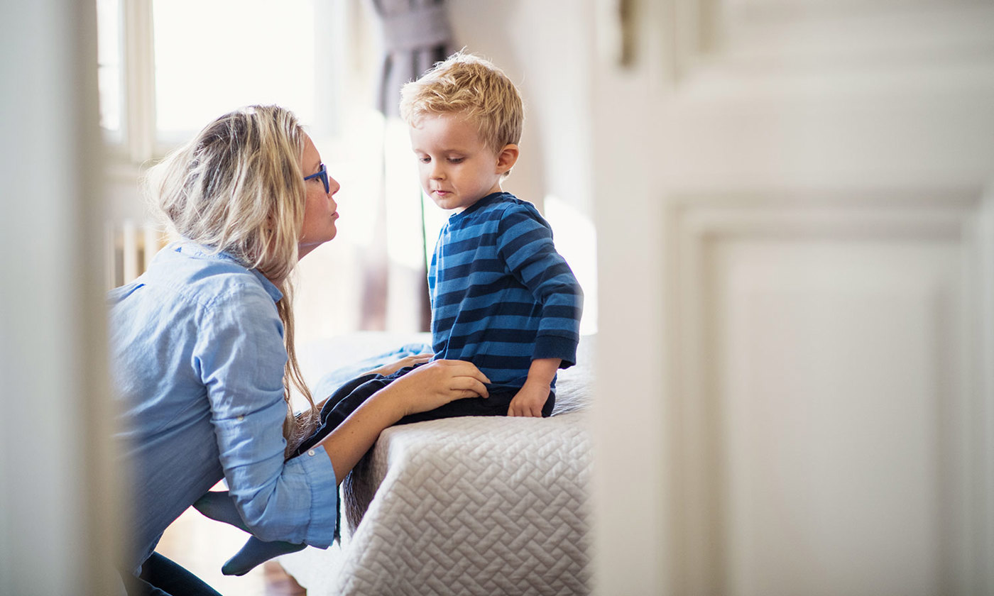 A young mother talking to her sad toddler son