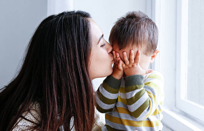 Mother kissing her little son