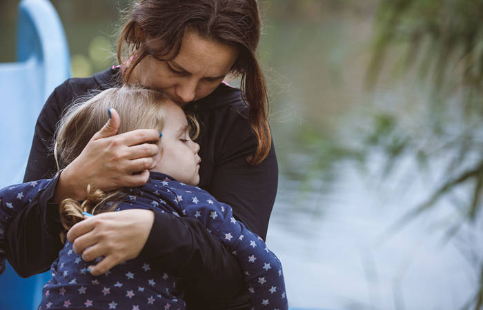 Little girl sleeping in her mother's arms