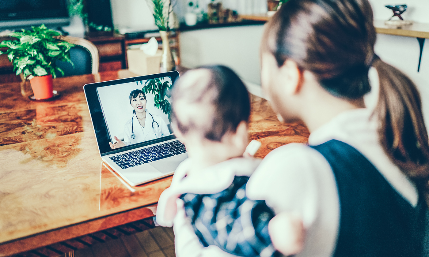 Mother and baby looking at a doctor on a computer