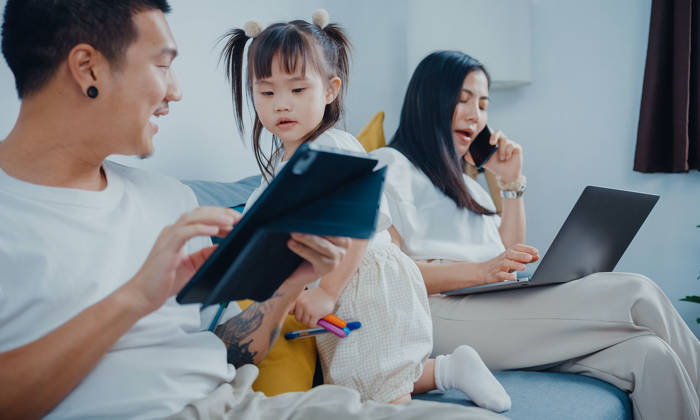 Mother and father working with children on lounge