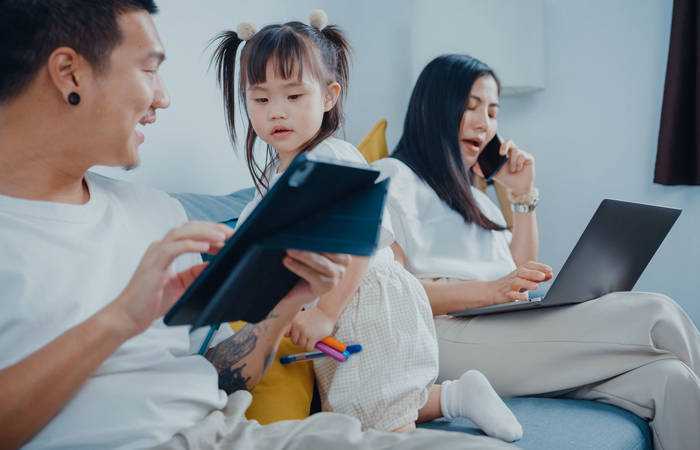 Mother and father working with children on lounge