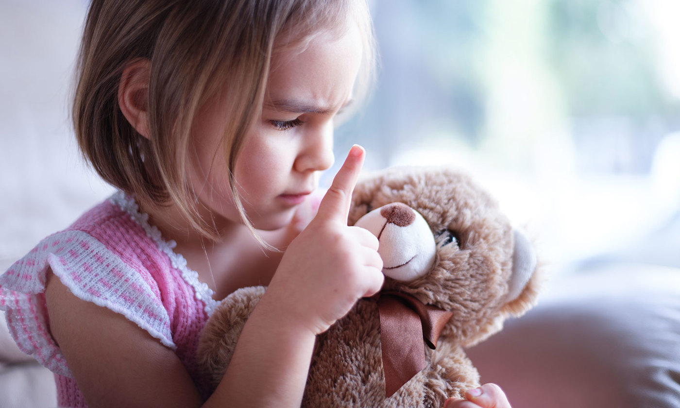 Little girl is angry with her toy bear