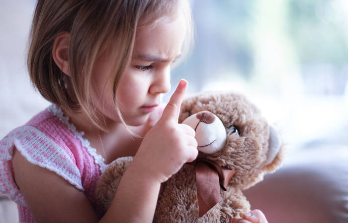 Little girl is angry with her toy bear