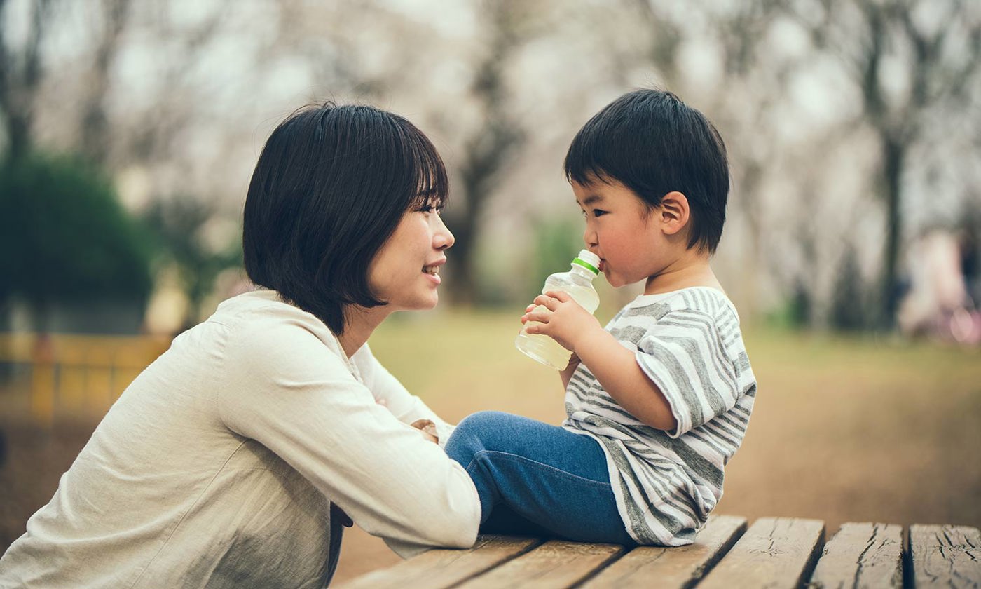 Mother and child sitting on bench and talking